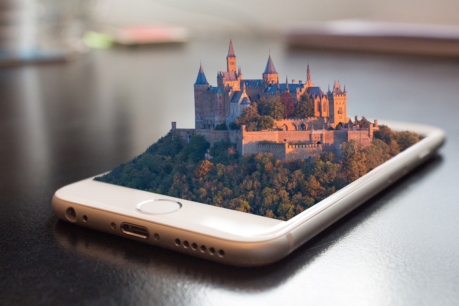 mobile phone with fairy tale castle rising up out of the screen to suggest the whole world available through the phone